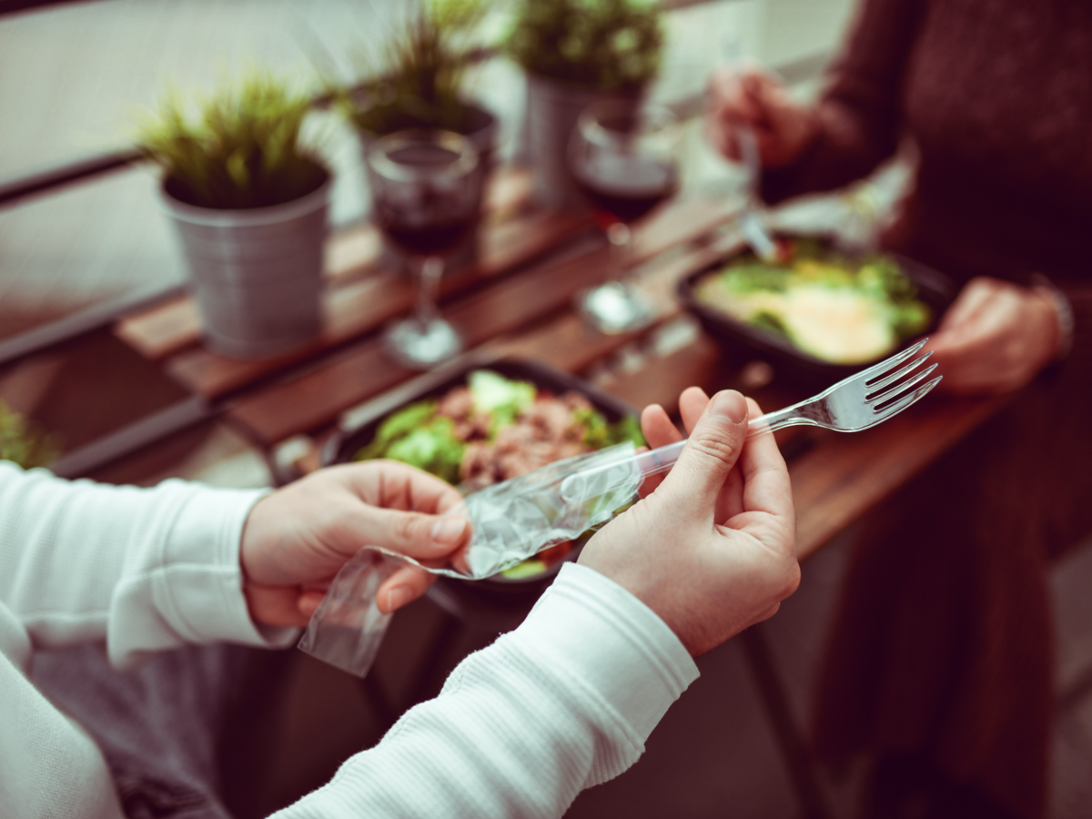 Person taking plastic fork out of a package