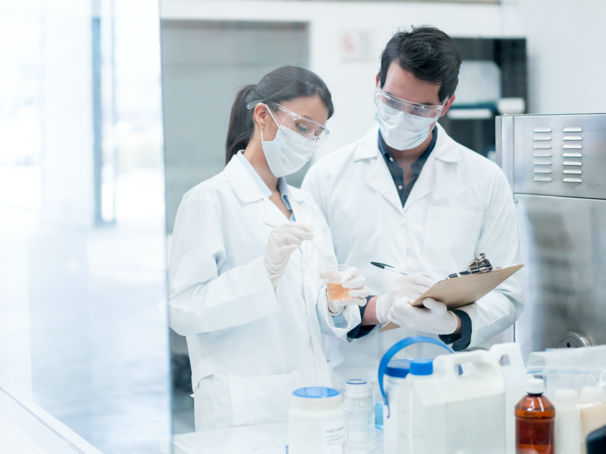 Two brunette scientists in lab with white coats