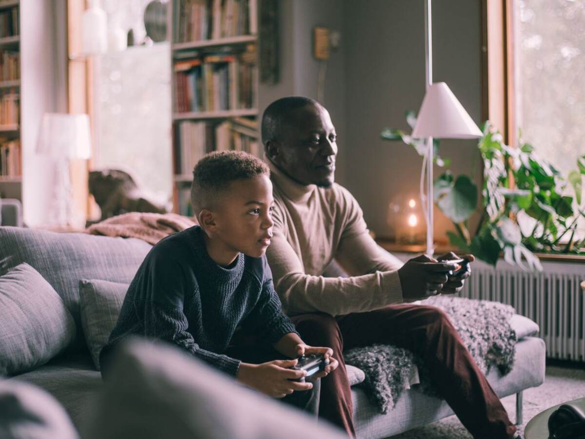 Father and son on sofa playing video game