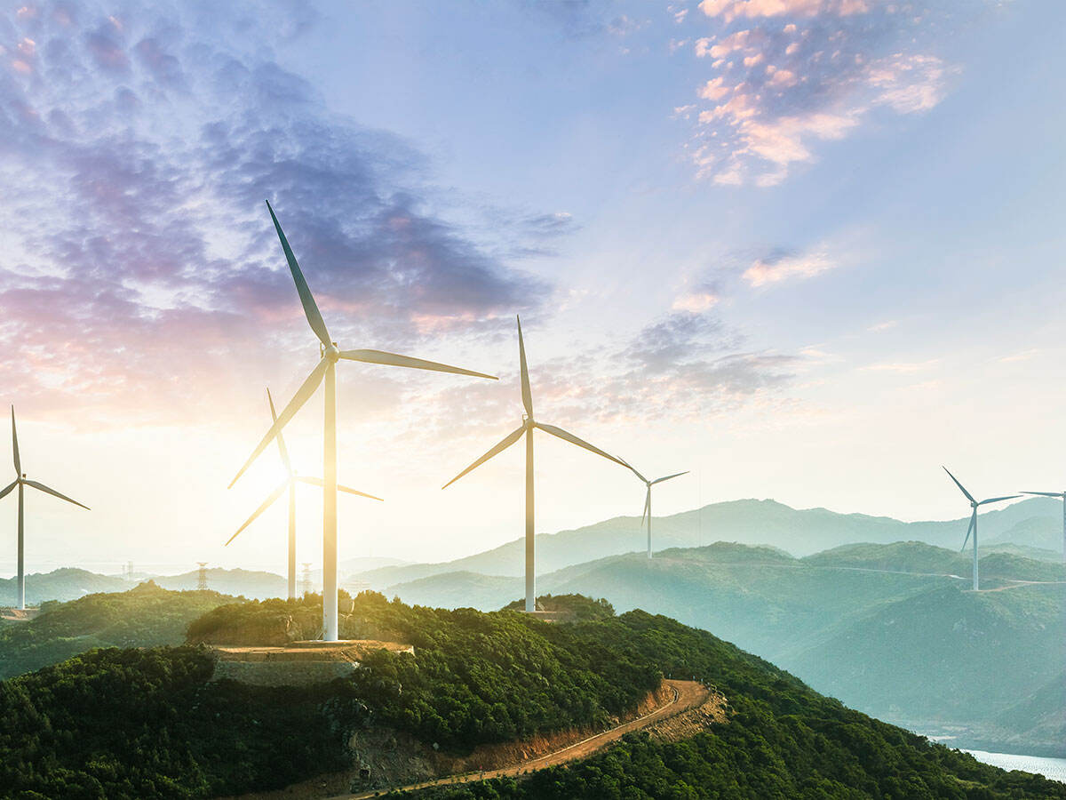 Wind farm on hillside with sunset in background