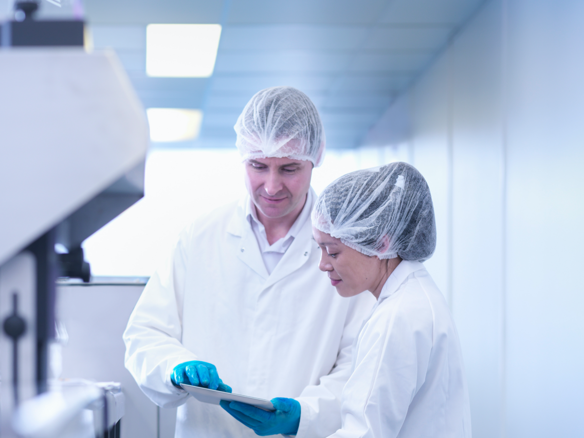 Man and woman scientists inspecting product in pharmaceutical factory