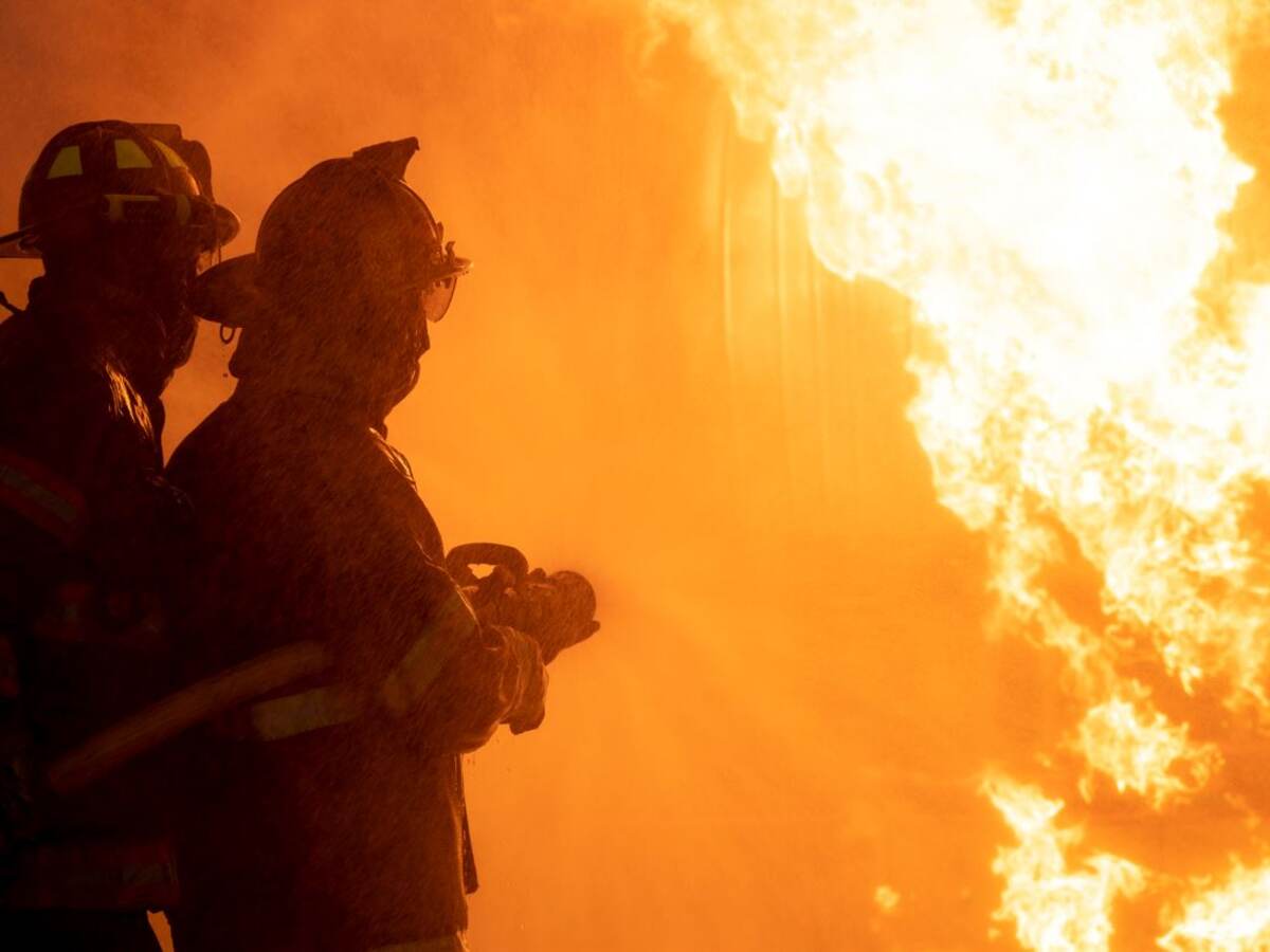 Two firefighters exinguishing a building fire