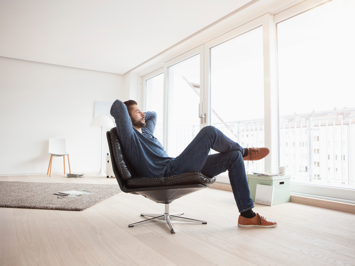 Man relaxing in an armchair conveying a sense of peace of mind, comfort and wellness.