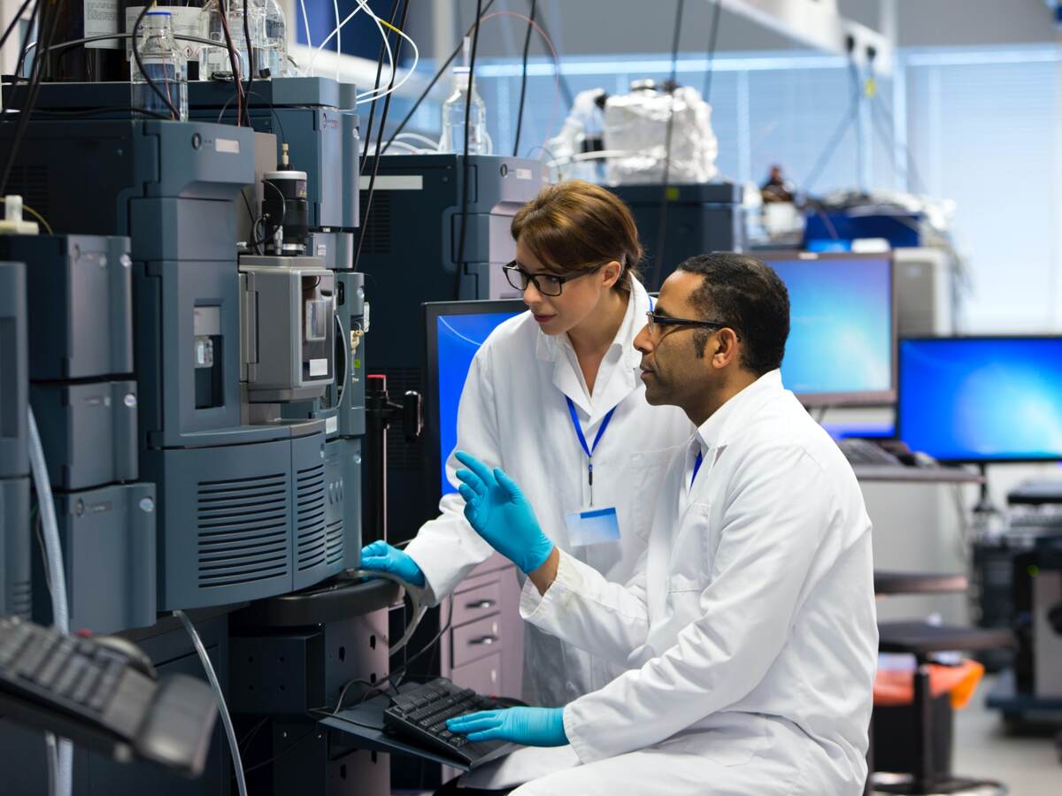 Laboratory technicians using specialized equipment for measuring chemicals