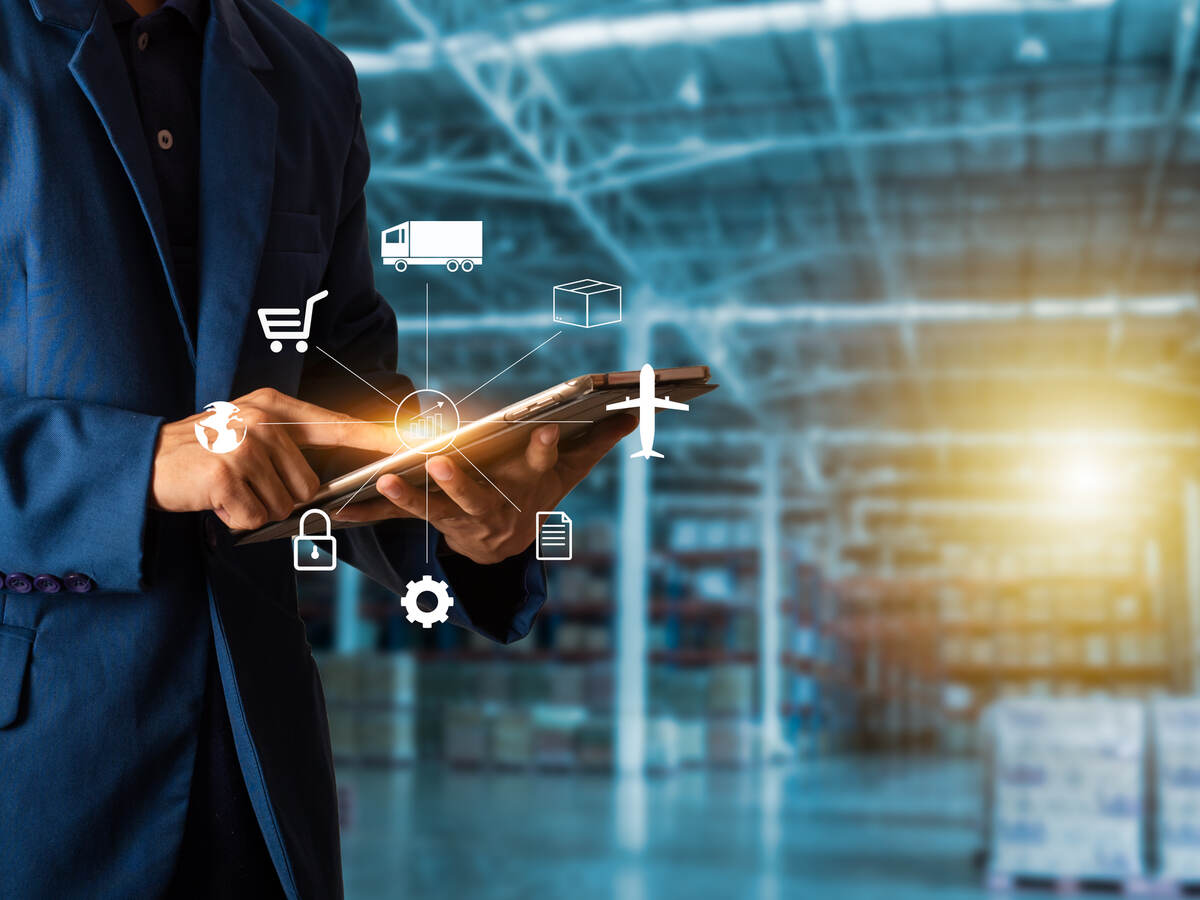 Man holding mobile device with inside factory