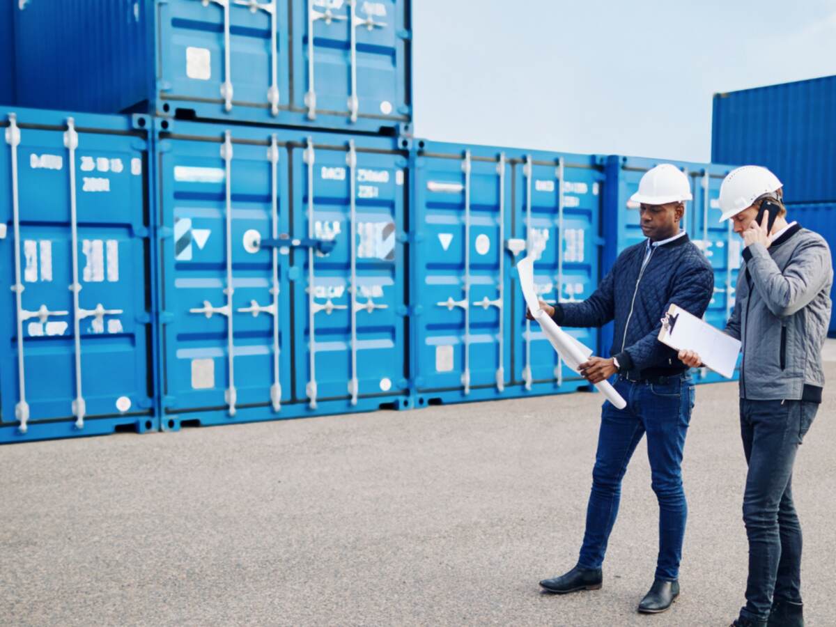 Logistics workers discussing paperwork.