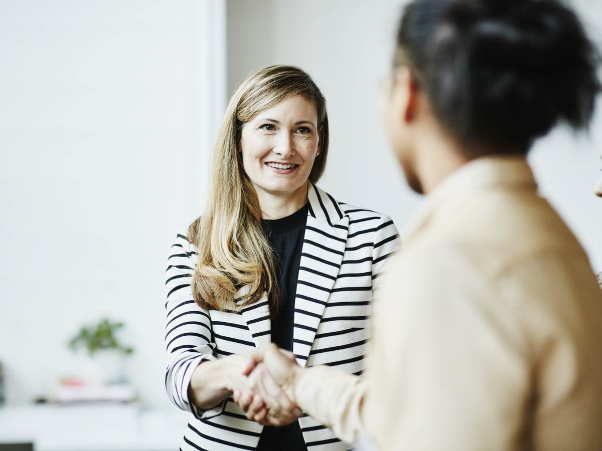 Smiling businesswoman shaking hands with client
