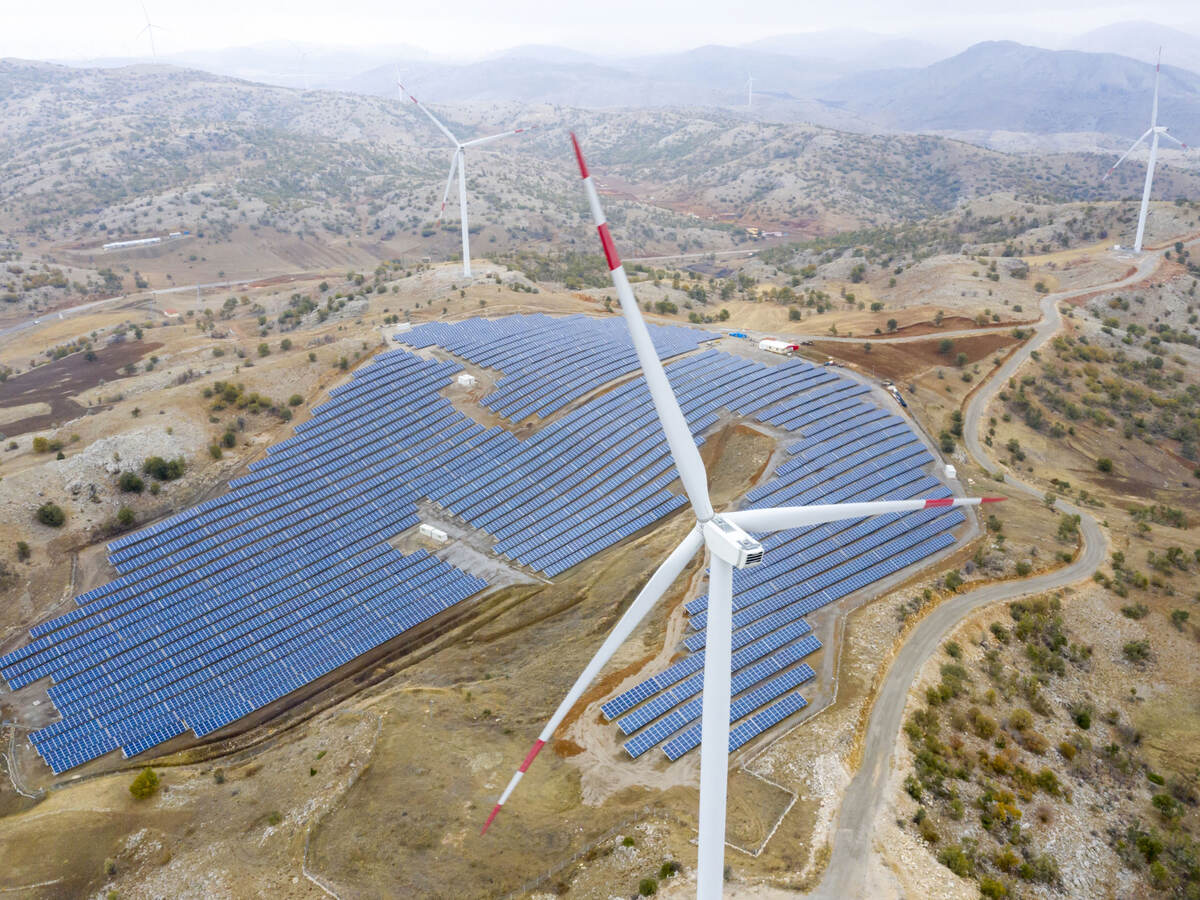 Aerial view of wind turbines and solar plant.