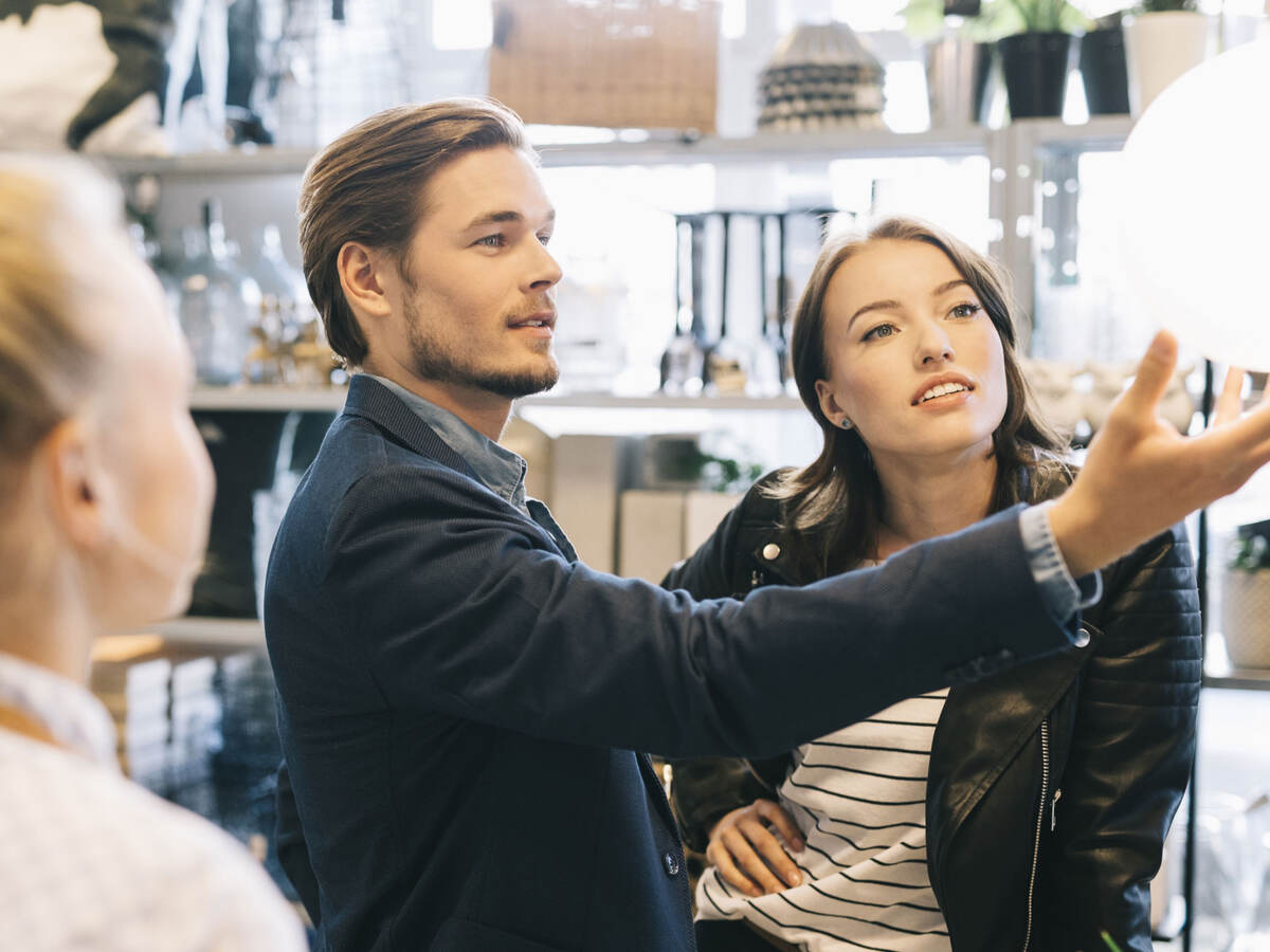 Customers shopping for lamps at a retail store.