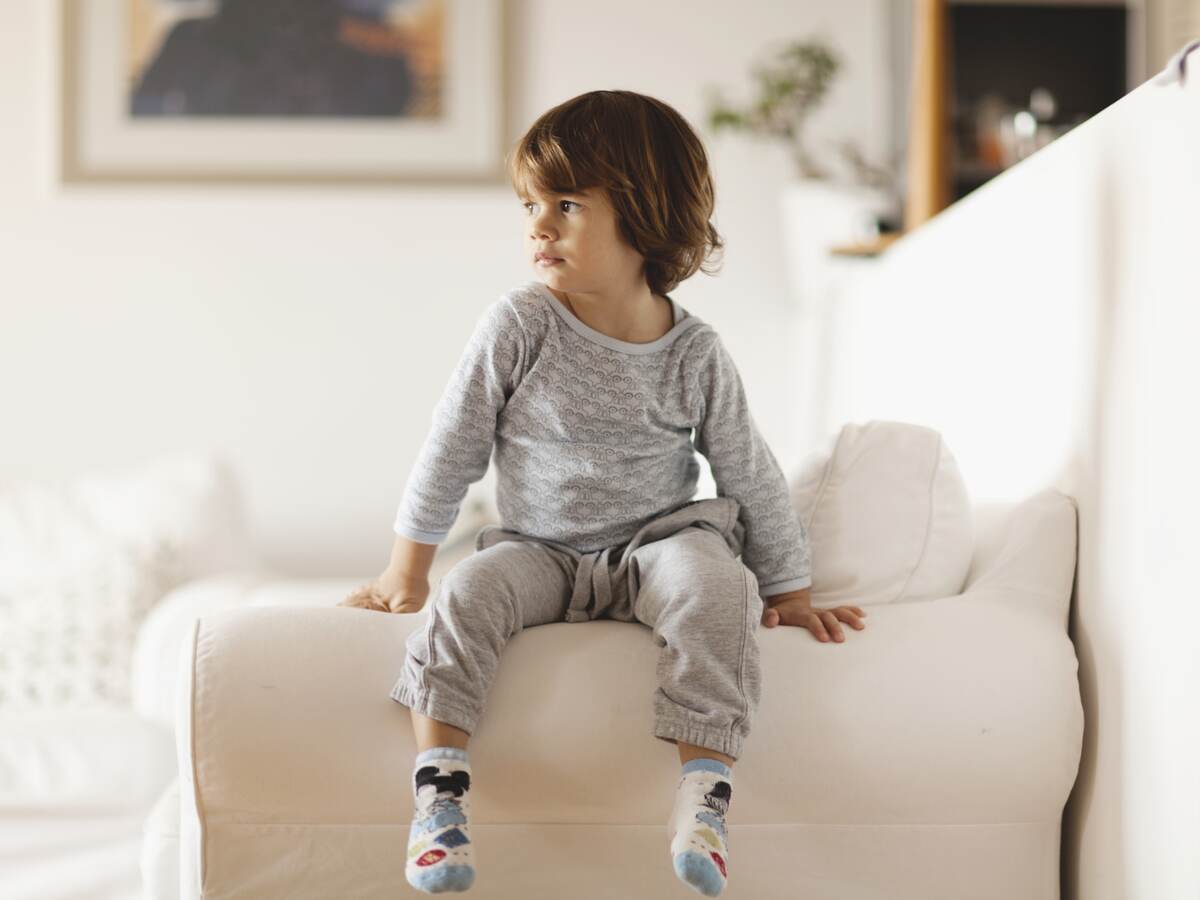 Child in pajamas sitting on a couch