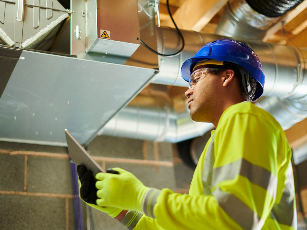 HVAC worker inspecting ceiling panel