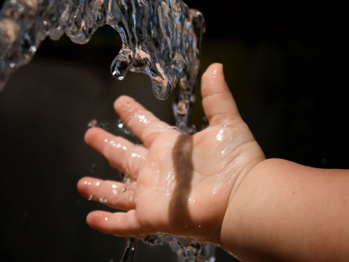 Baby holding hand under running water