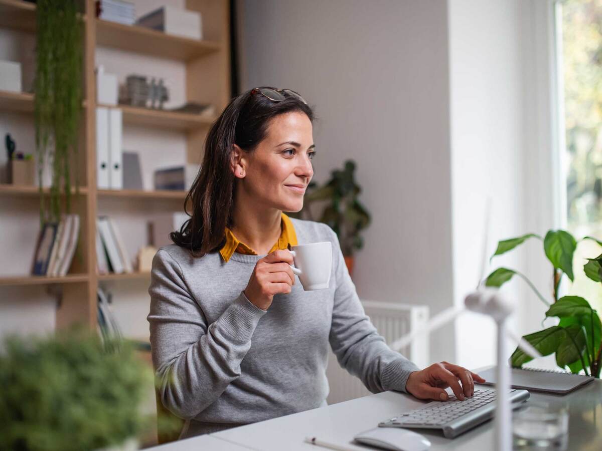 Person in home office setting, with a cup of coffee