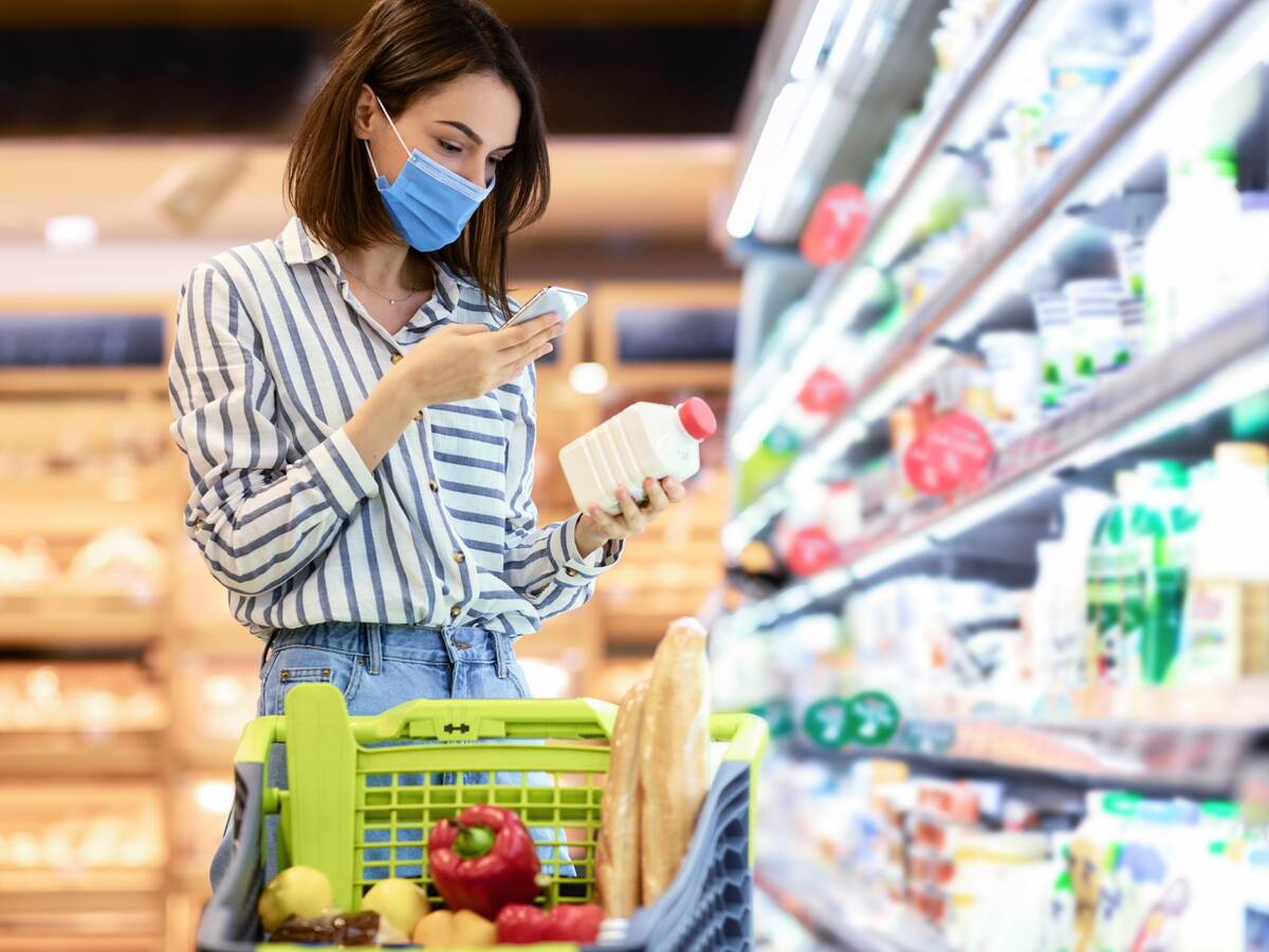 Person in supermarket checking a label on a food product