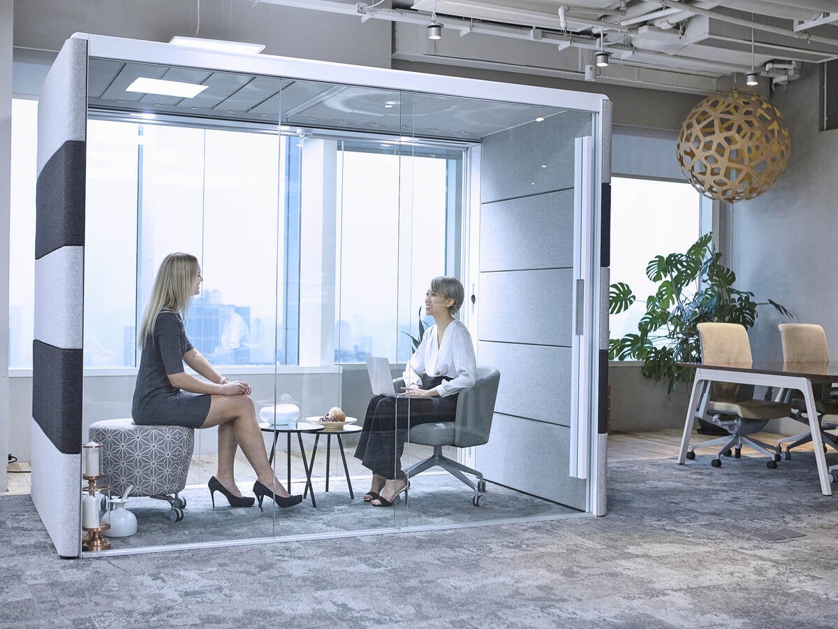Office workers using a privacy booth