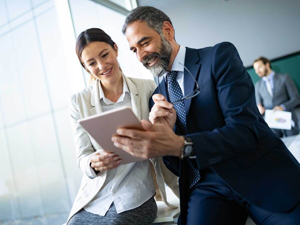 Two coworkers looking at a tablet