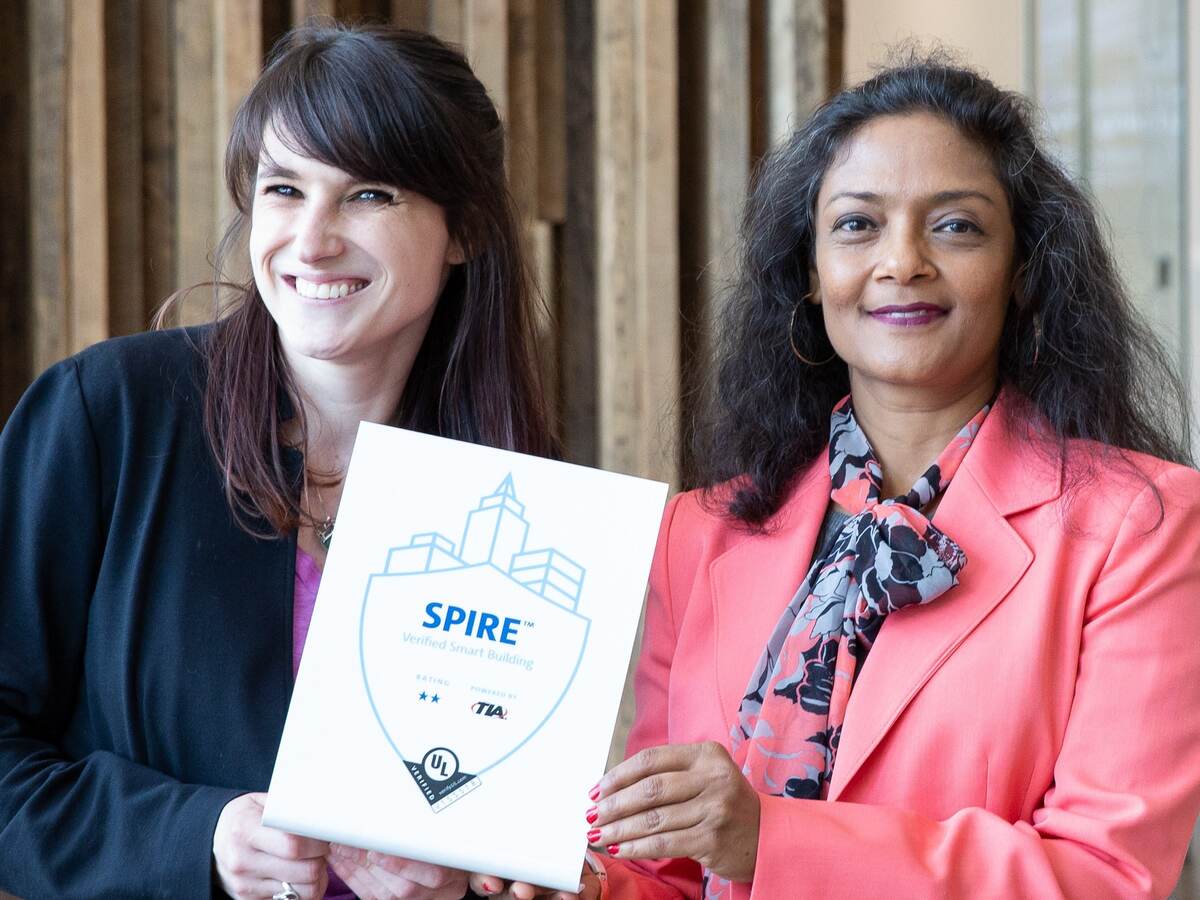Two women from UL and MRP Realty hold up SPIRE plaque. 