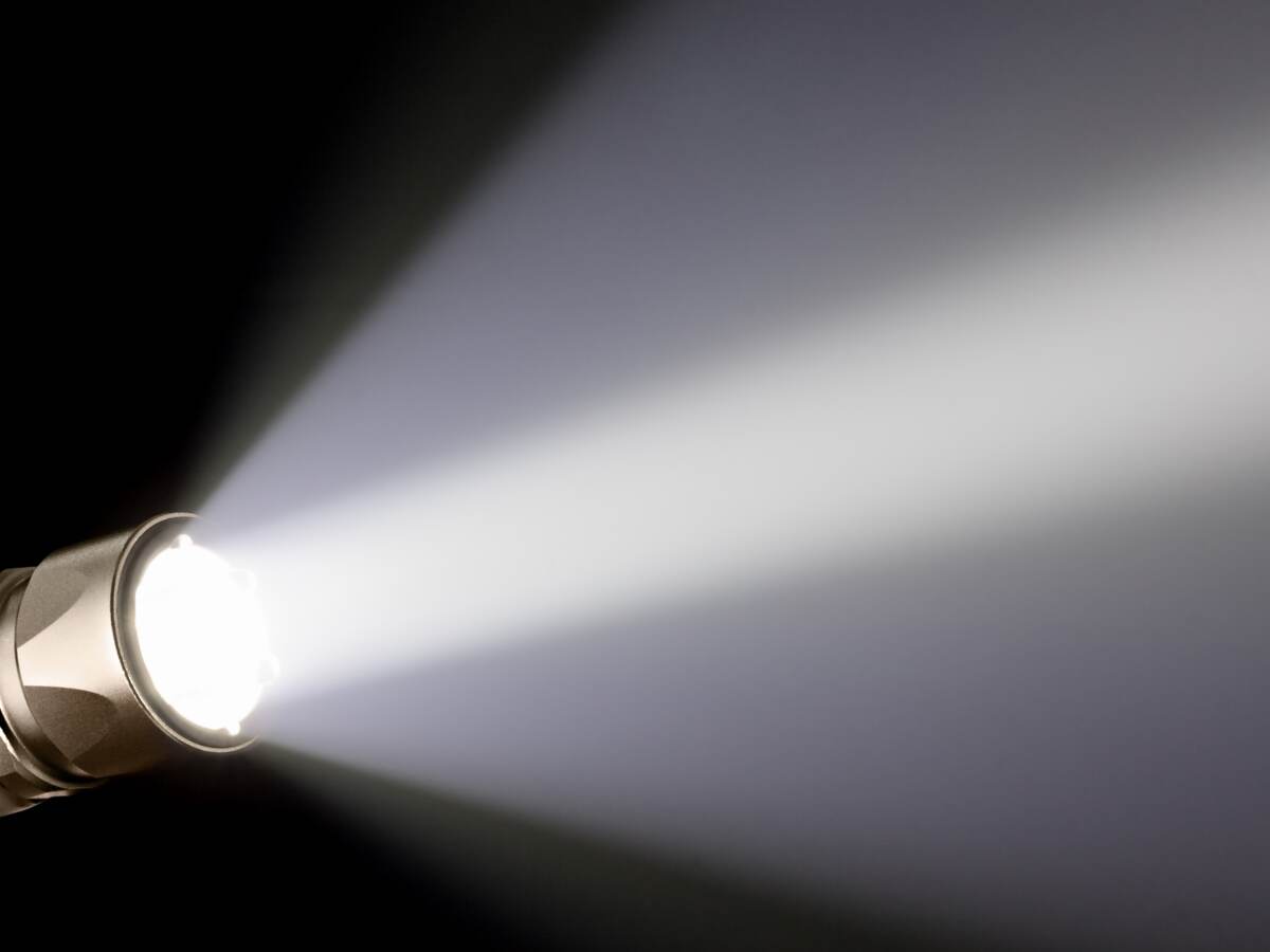 A piercing beam of light from a handheld flashlight.