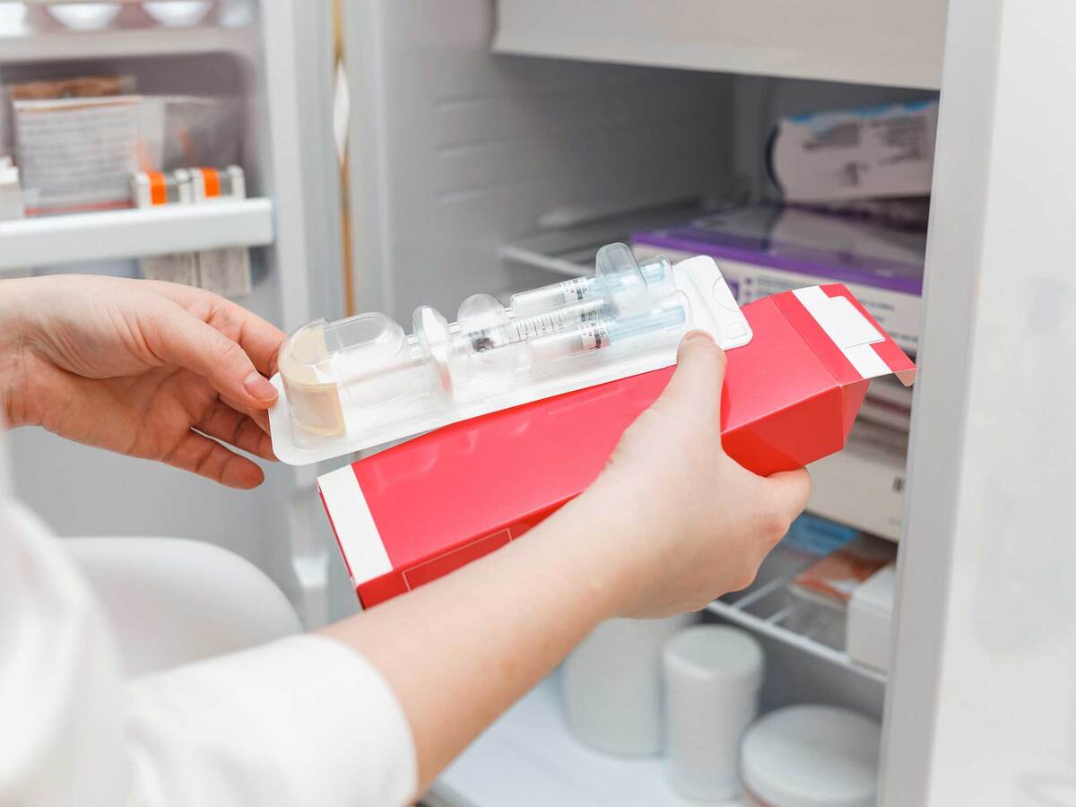 Laboratory technician retrieving refrigerated vaccines