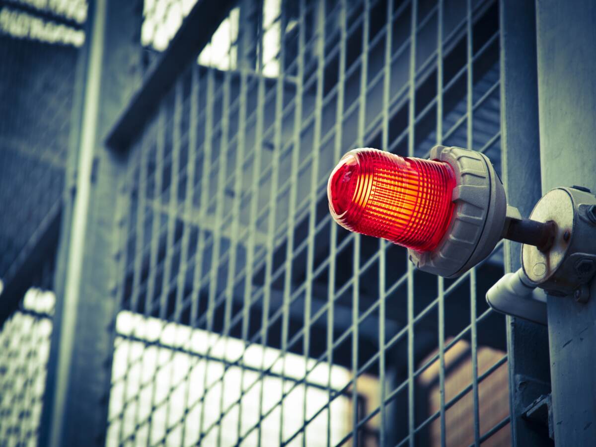 A red emergency light over a commercial building door.