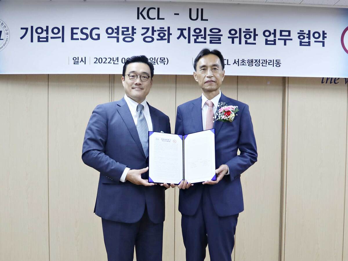 Image of two people holding certificate at signing ceremony
