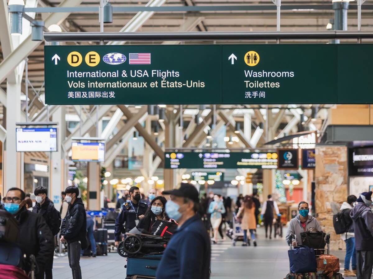 Airport terminal at the Vancouver International Airport with passengers wearing face mask