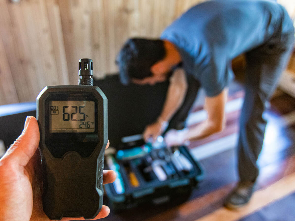 Technicians use a device to measure moisture levels