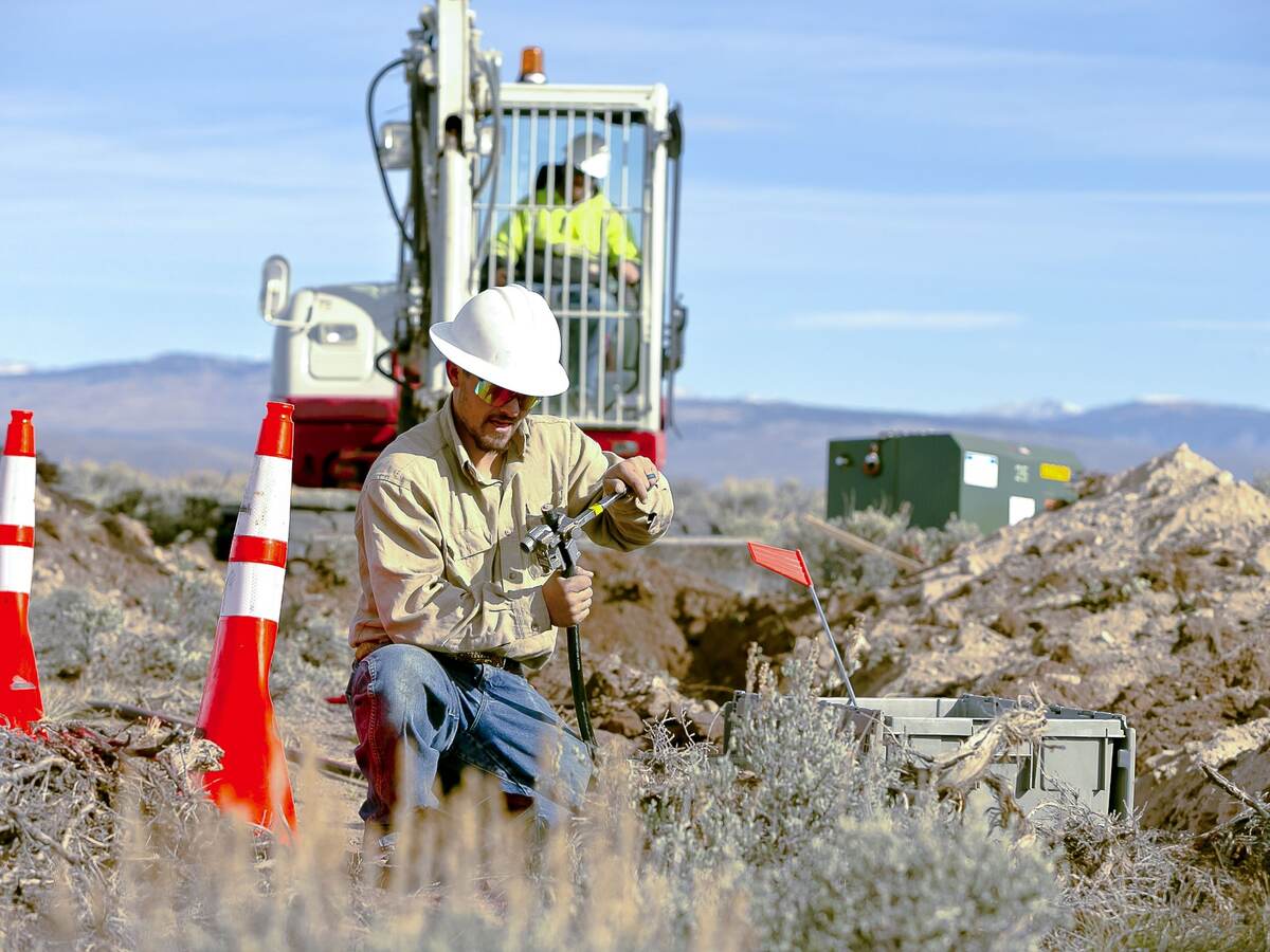 Worker installing cables for underground distribution.