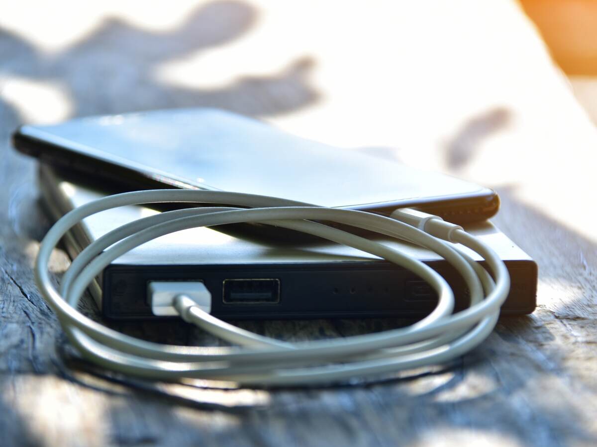 Close-up of mobile phone connected to portable charger on table