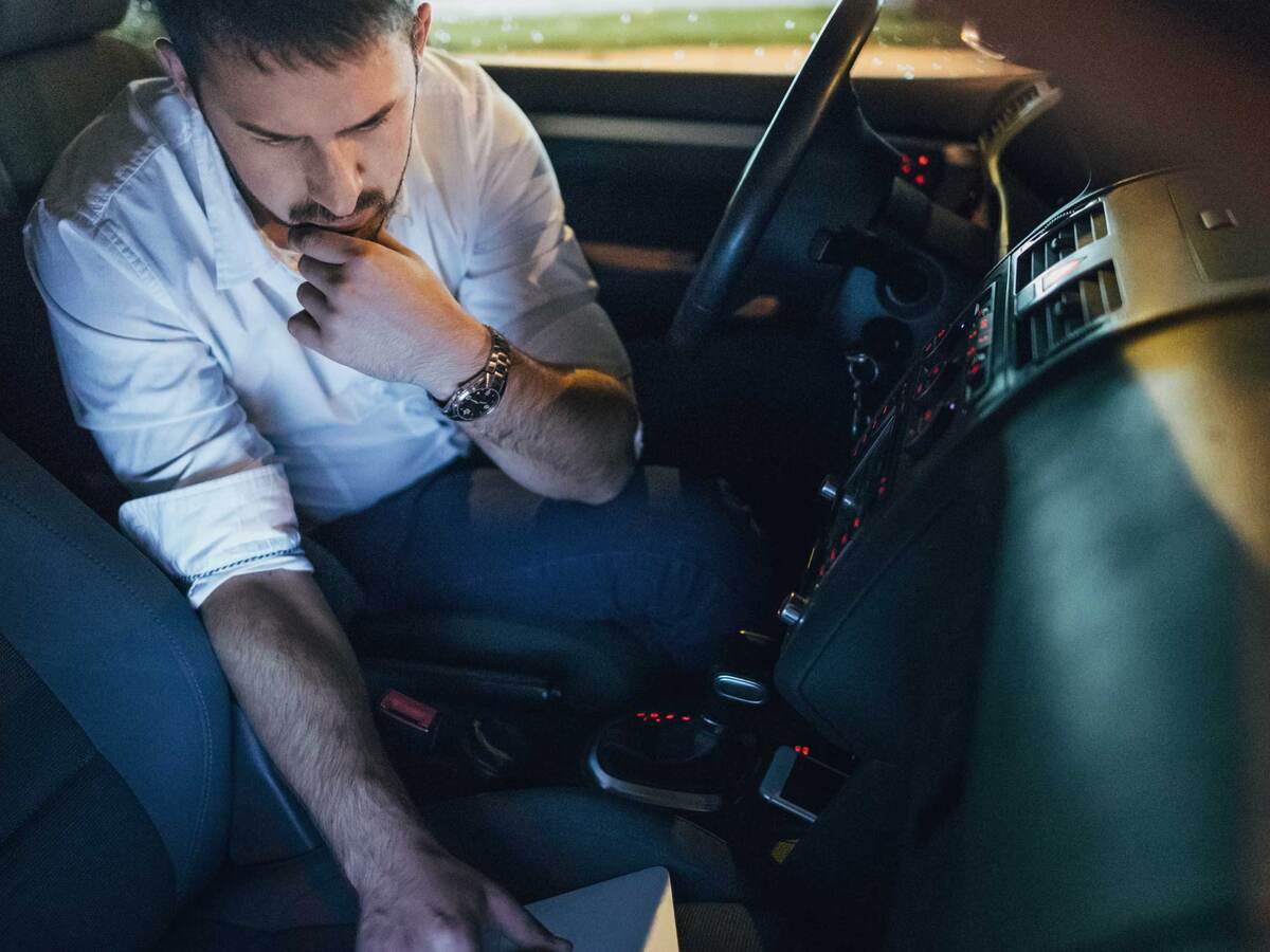 Man using laptop in a car