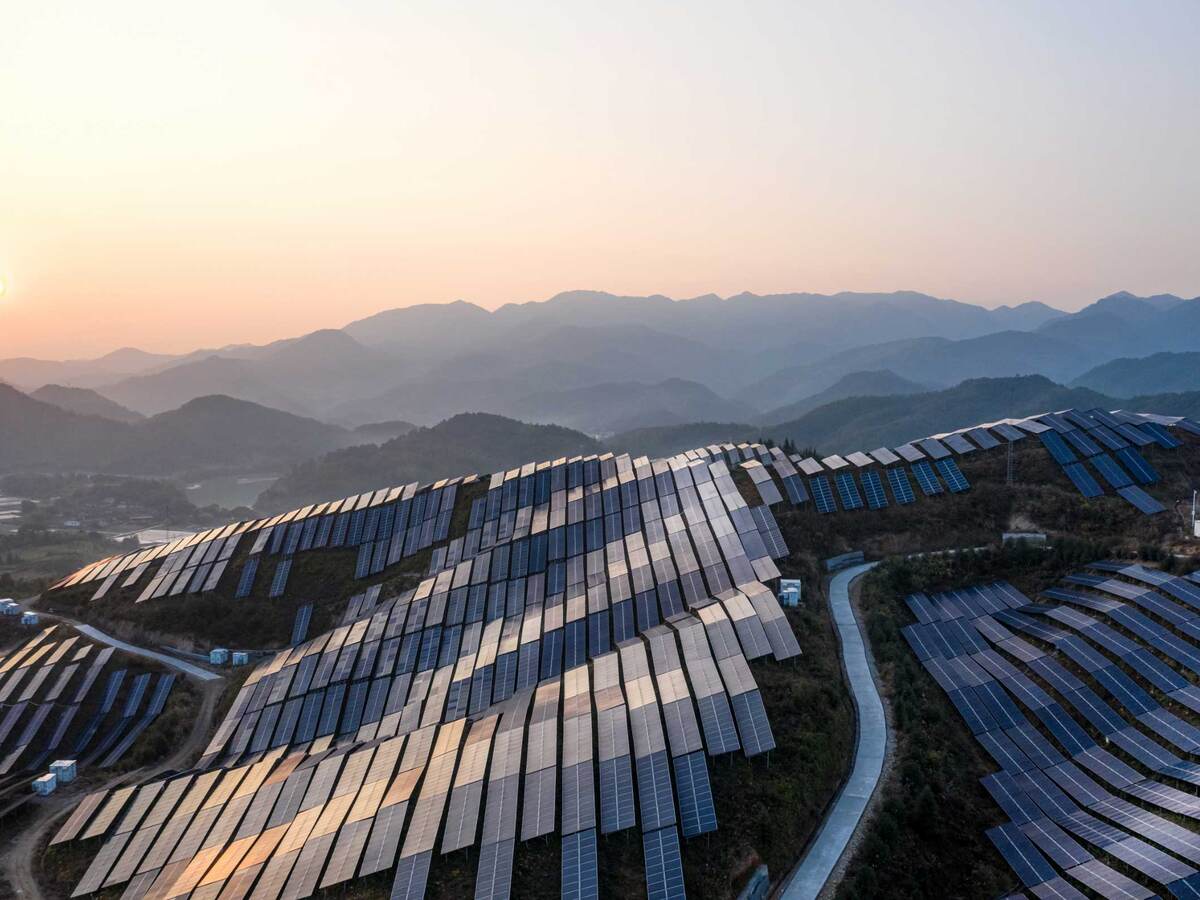 Aerial view of the solar power plant on the top of the mountain at sunset