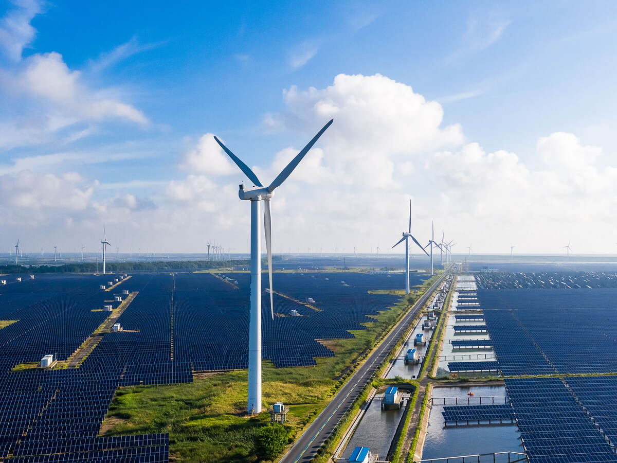 Solar power stations with wind turbines in distance