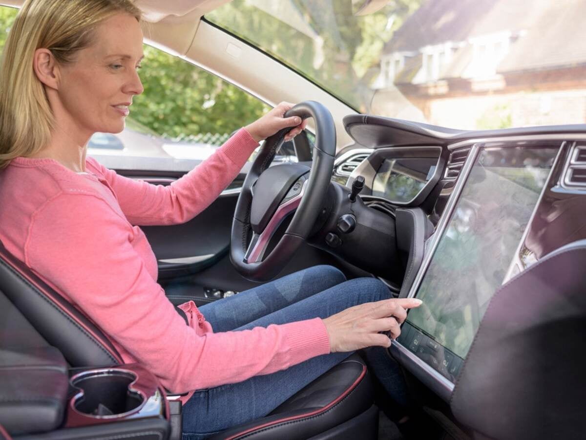 woman in a car touching navigation screen