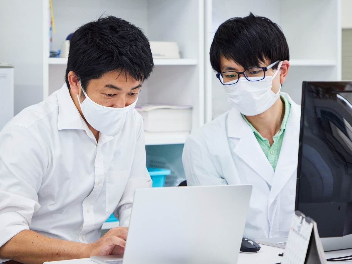 Life science researchers examining data on a laptop computer. 