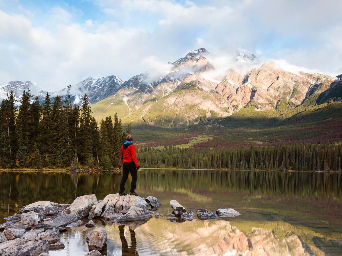 A person standing in a stream looking at a mountain