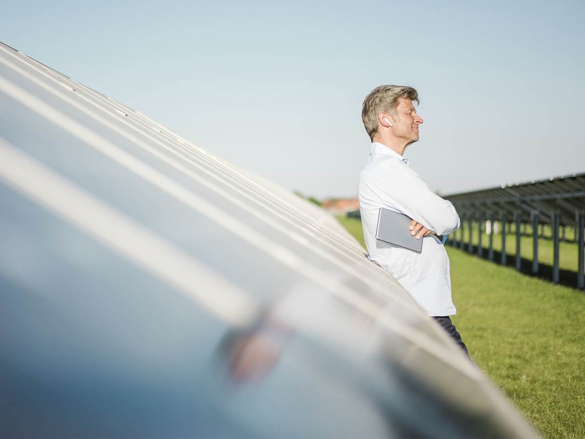 Man standing in front of a row of solar panels. 