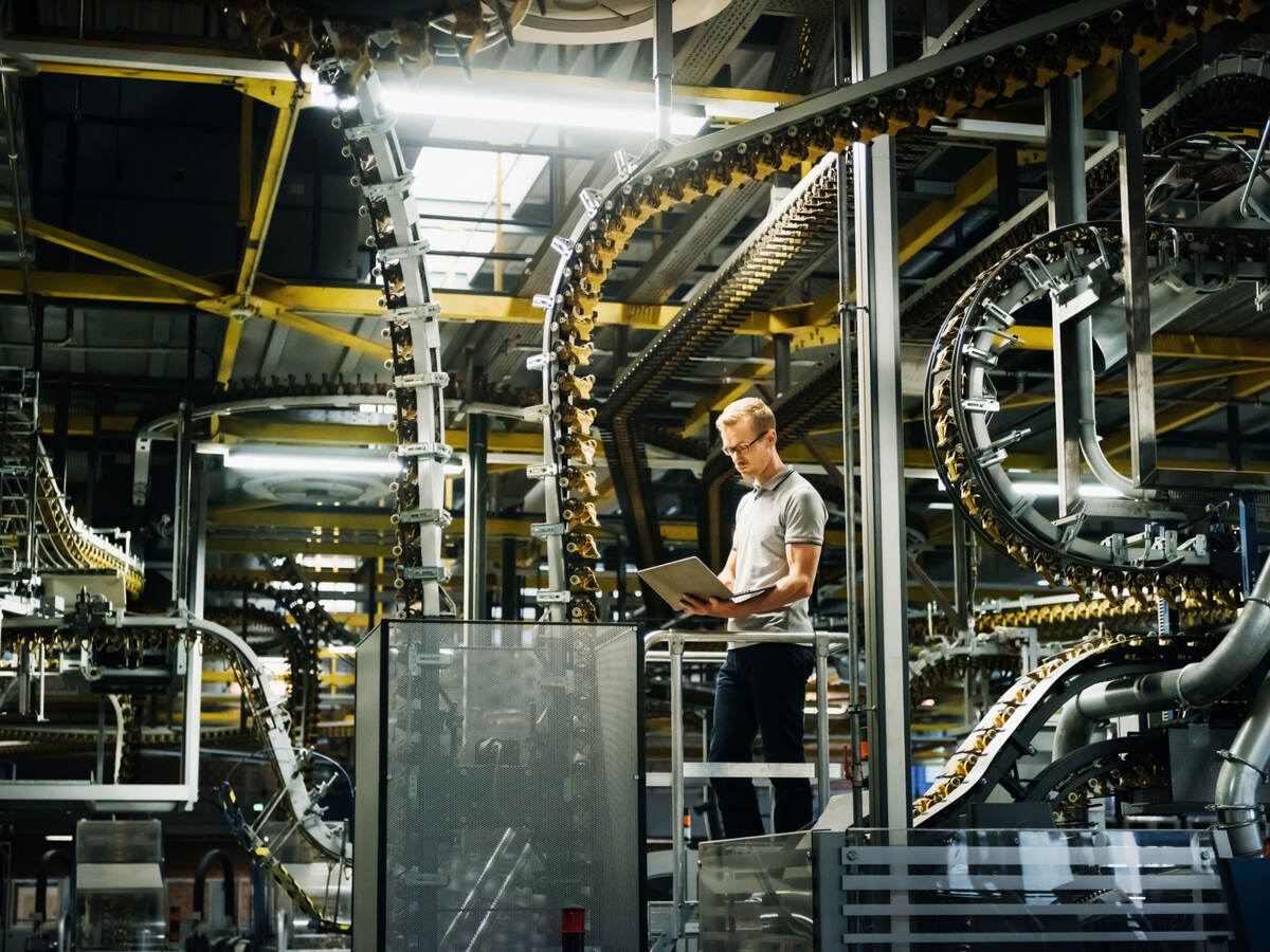 Engineer with laptop in a factory