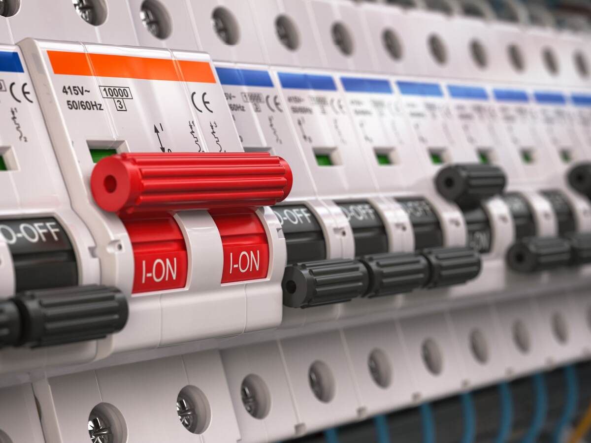 Switches in fusebox. Many black circuit brakers in a row in position OFF and one red switch in position ON.