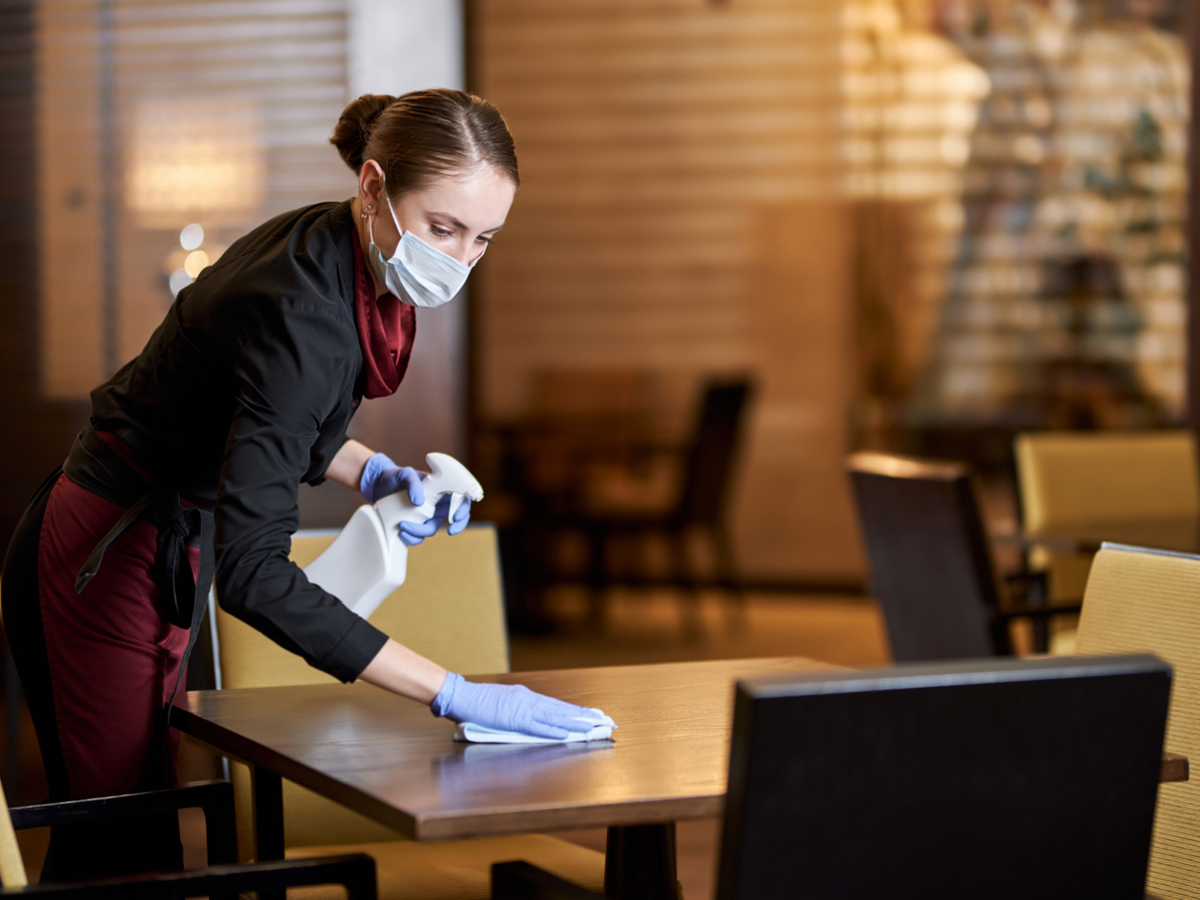 Waitress in uniform cleaning restaurant table