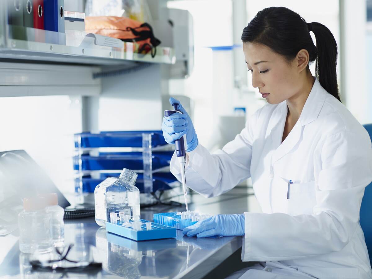 Scientist pipetting samples into tubes.