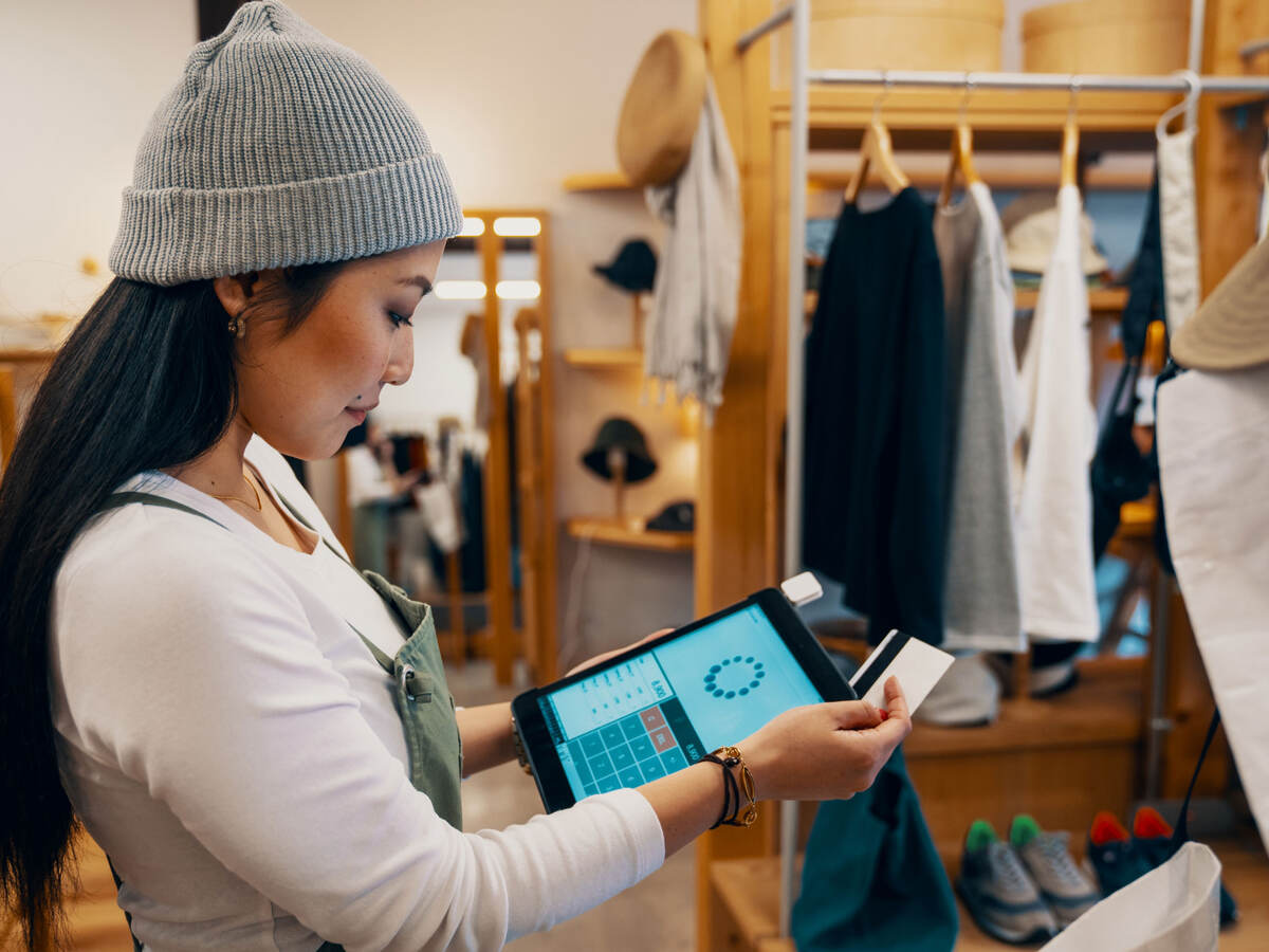 Retail shop clerk taking a mobile credit card payment on a digital tablet