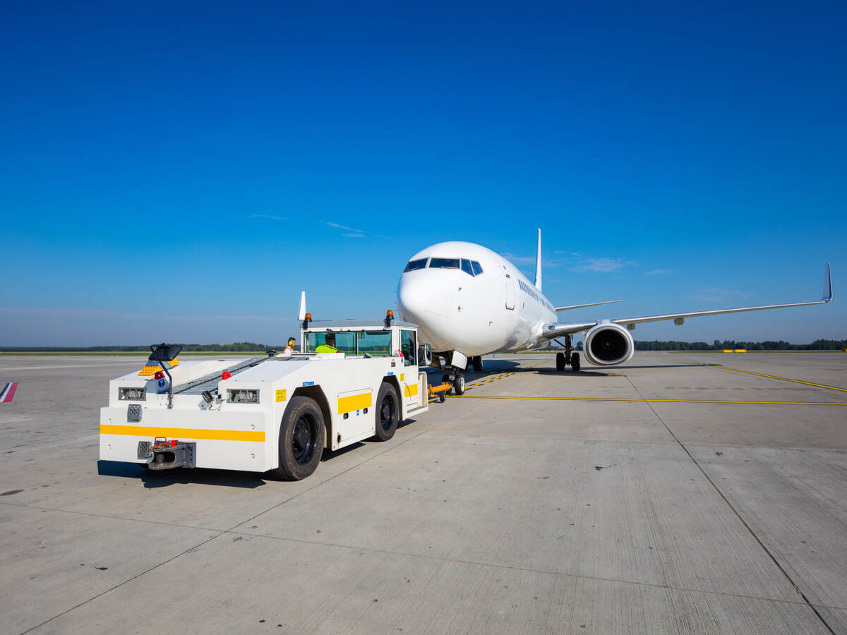 Aviation ground support equipment vehicle and airplane on a runway