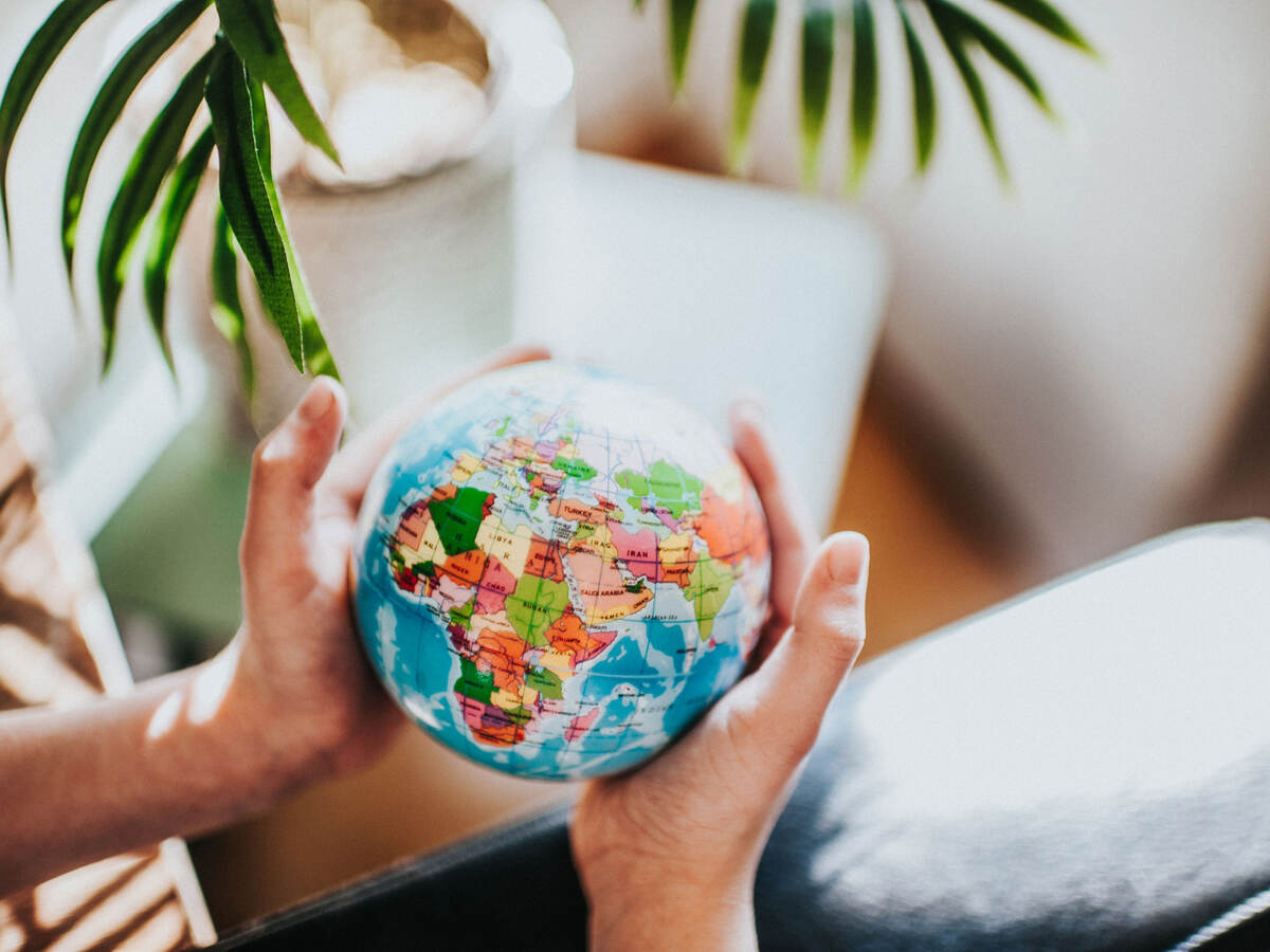 Person holding a small globe in their hands