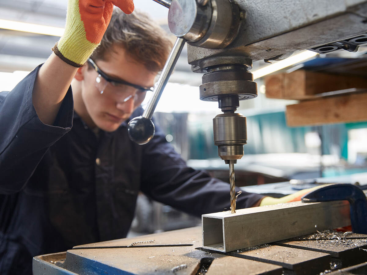 apprentice using pillar drill 