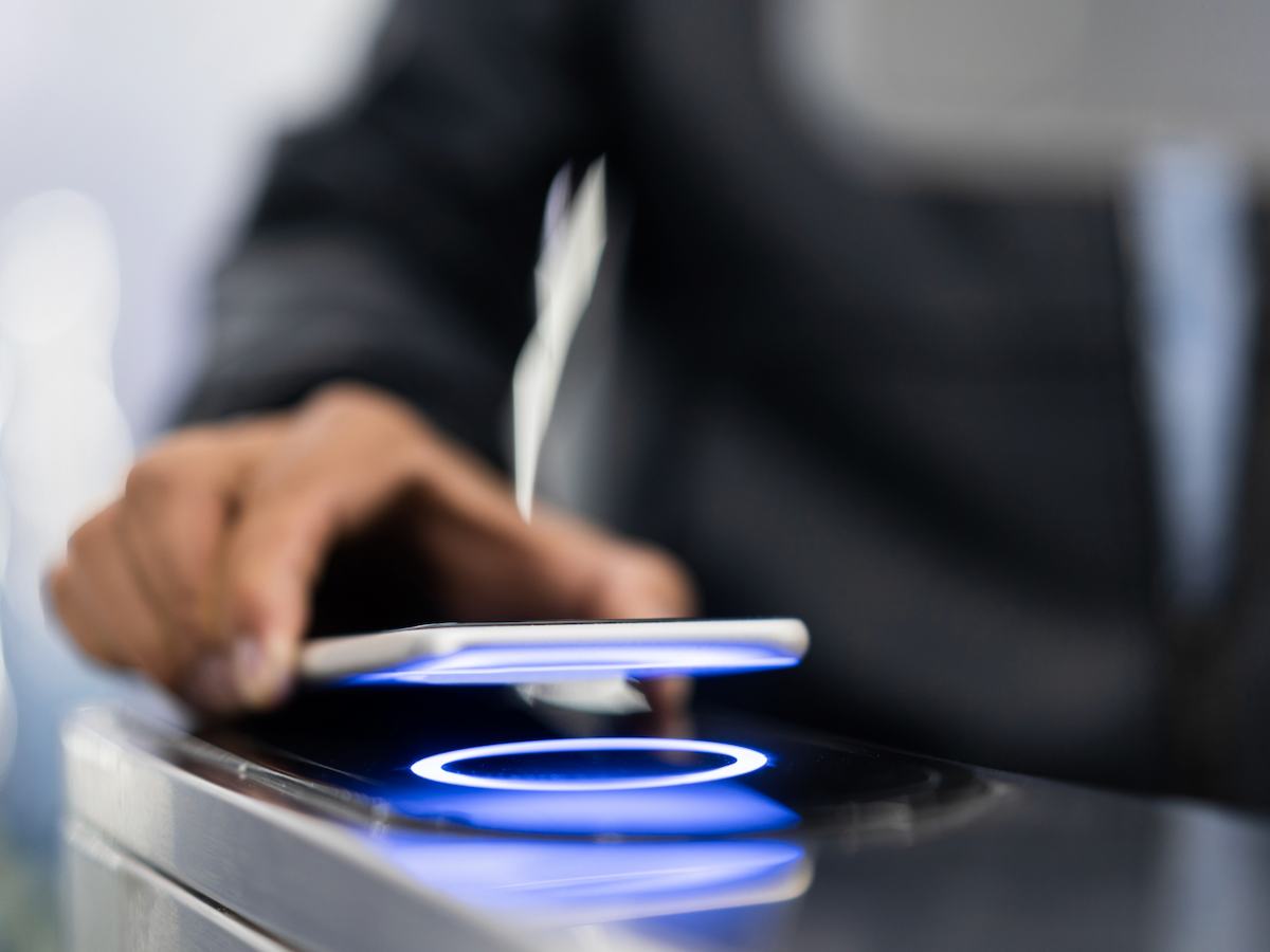 Person with smartphone accessing entry into a building through smart entry system