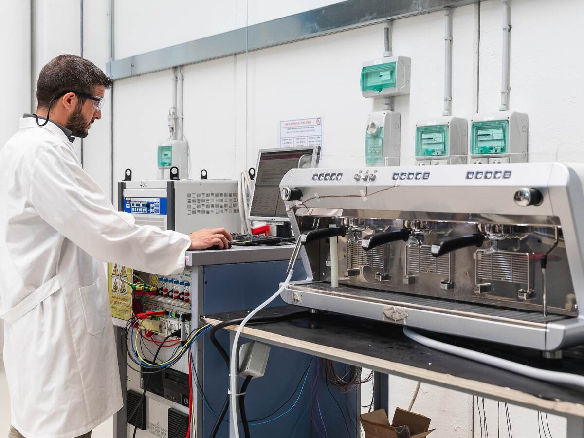 Laboratory technician conducting test on espresso machine.