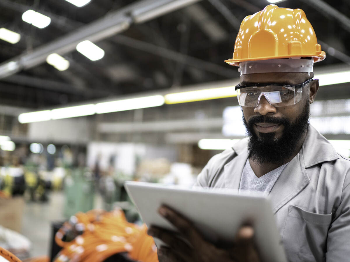 Man working with a digital tablet in a factory