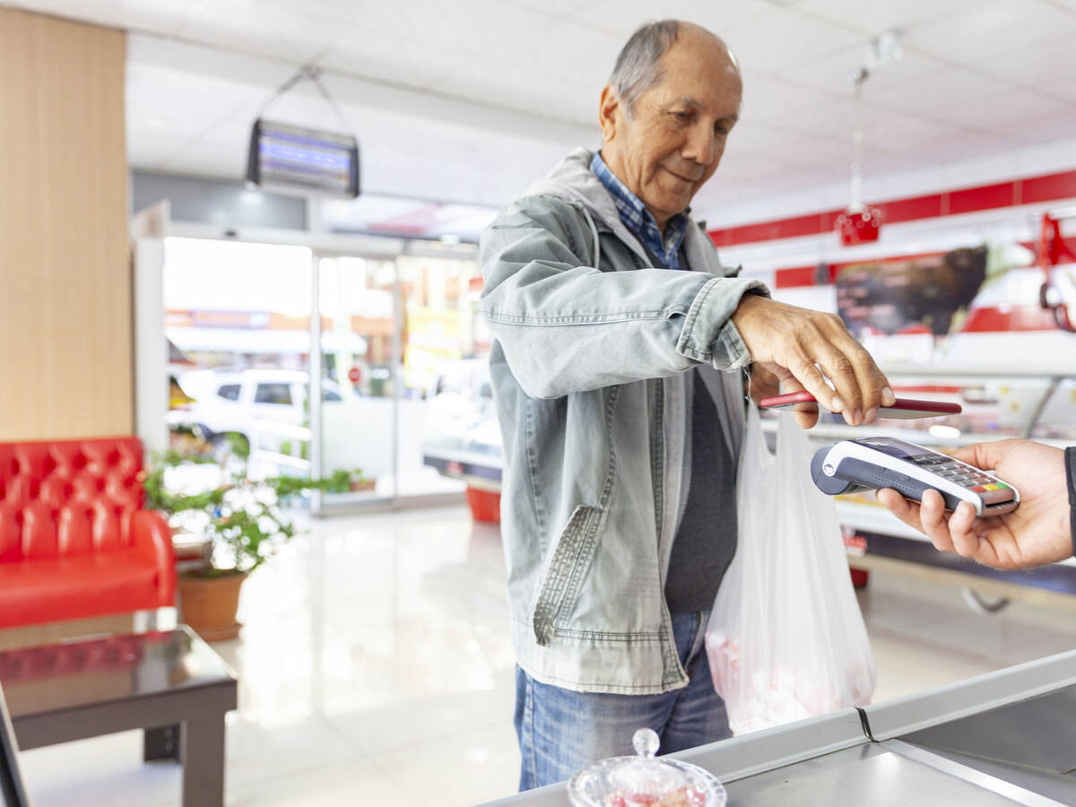 Elderly person pays for groceries via contactless payment