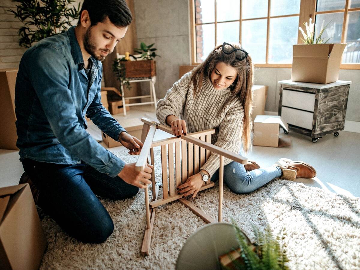 Young couple assembling furniture for new home