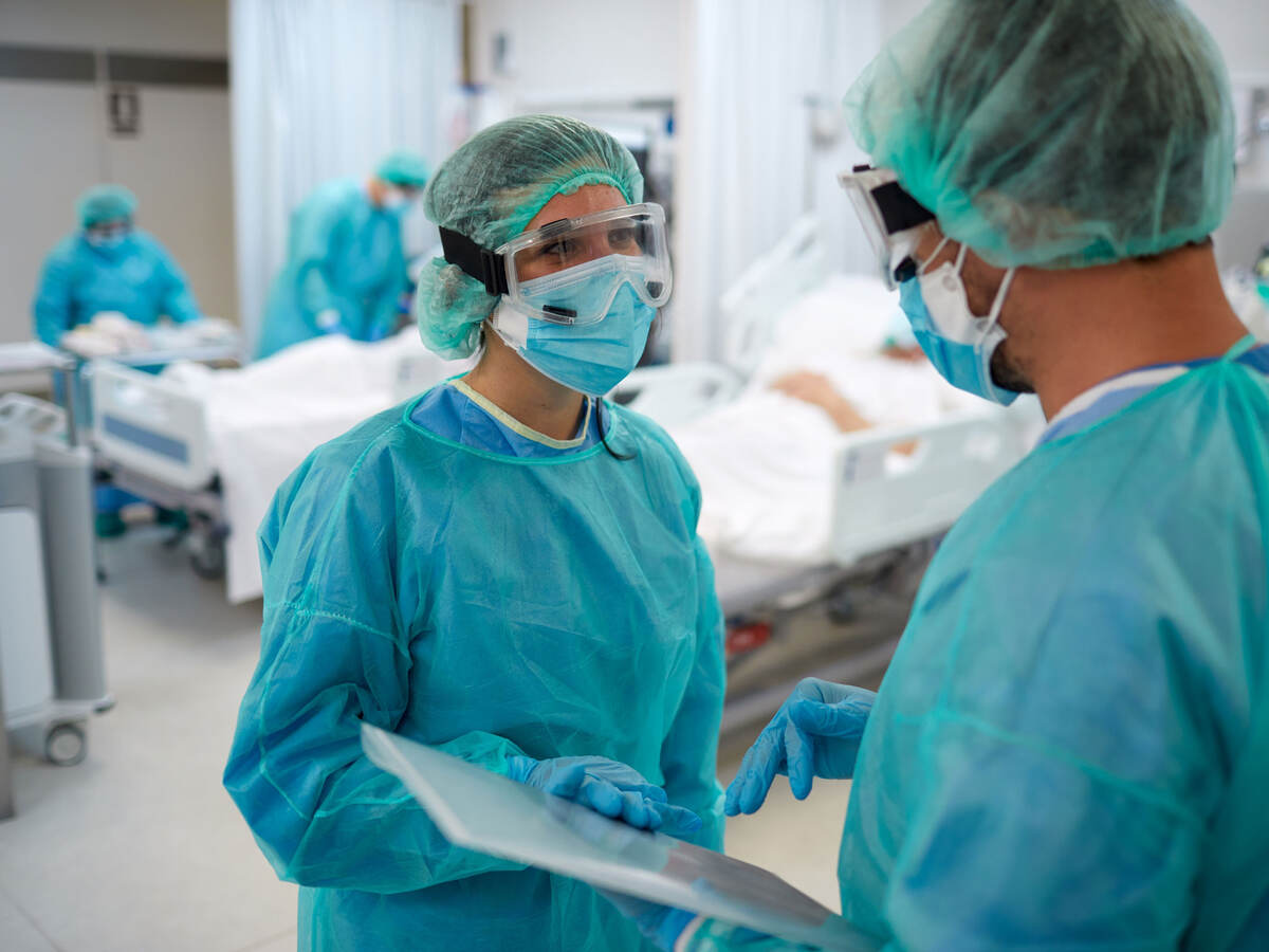 Two doctors talking and wearing PPE